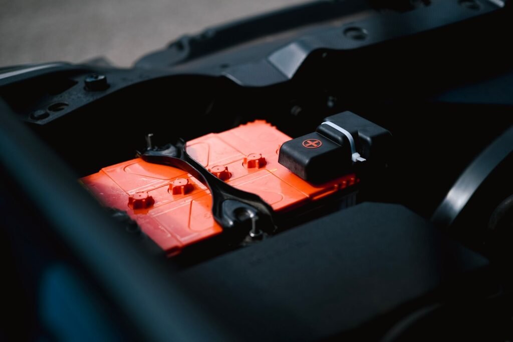 Bateria fraca de carro sendo verificada no vão do motor