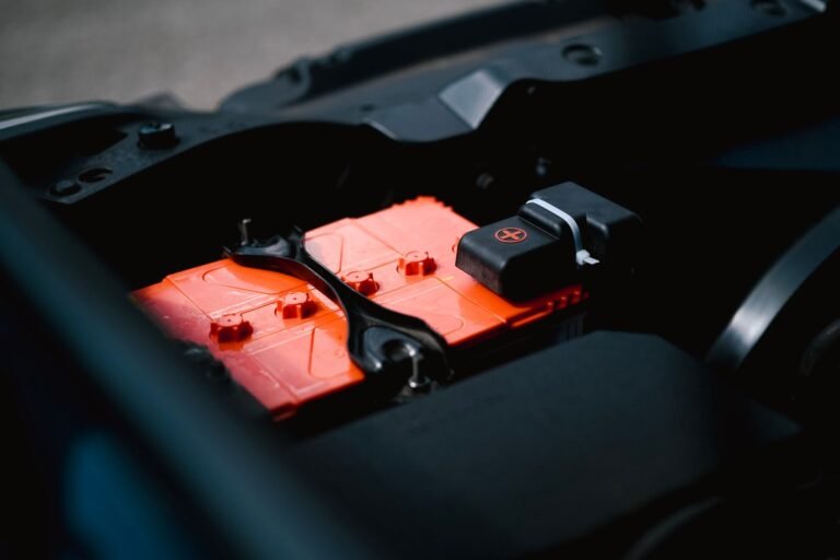 Bateria fraca de carro sendo verificada no vão do motor