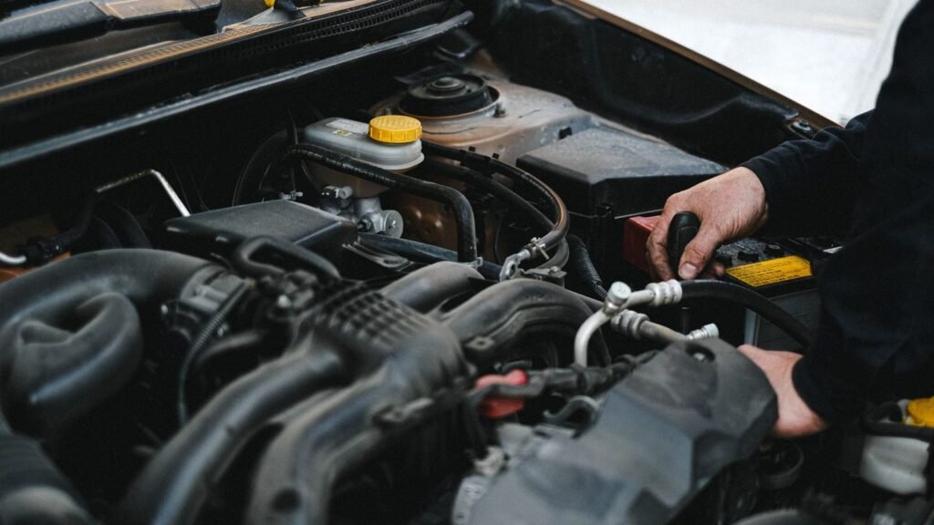 Mão de mecânico no motor de um carro: motor engasgando ao acelerar