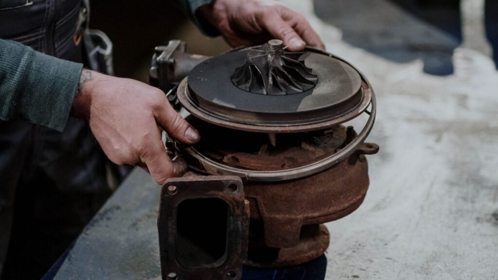 Mecânico segurando uma turbina de turbocompressor desmontada: motor turbo perdendo força