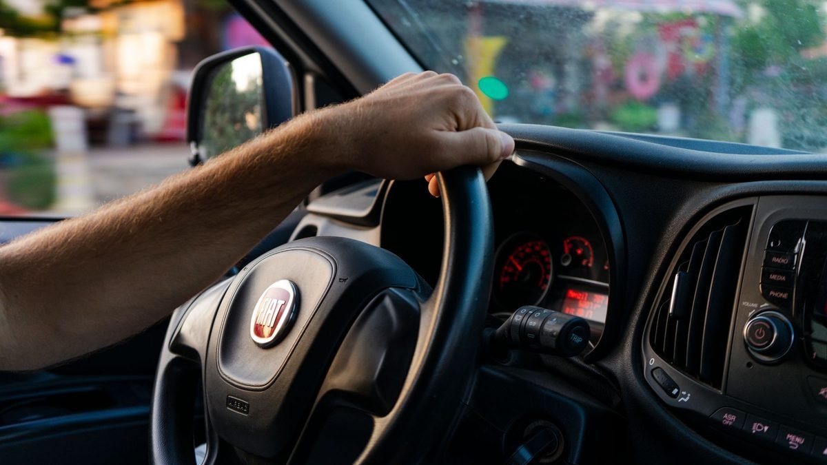 Mãos de motorista ao volante de um carro
