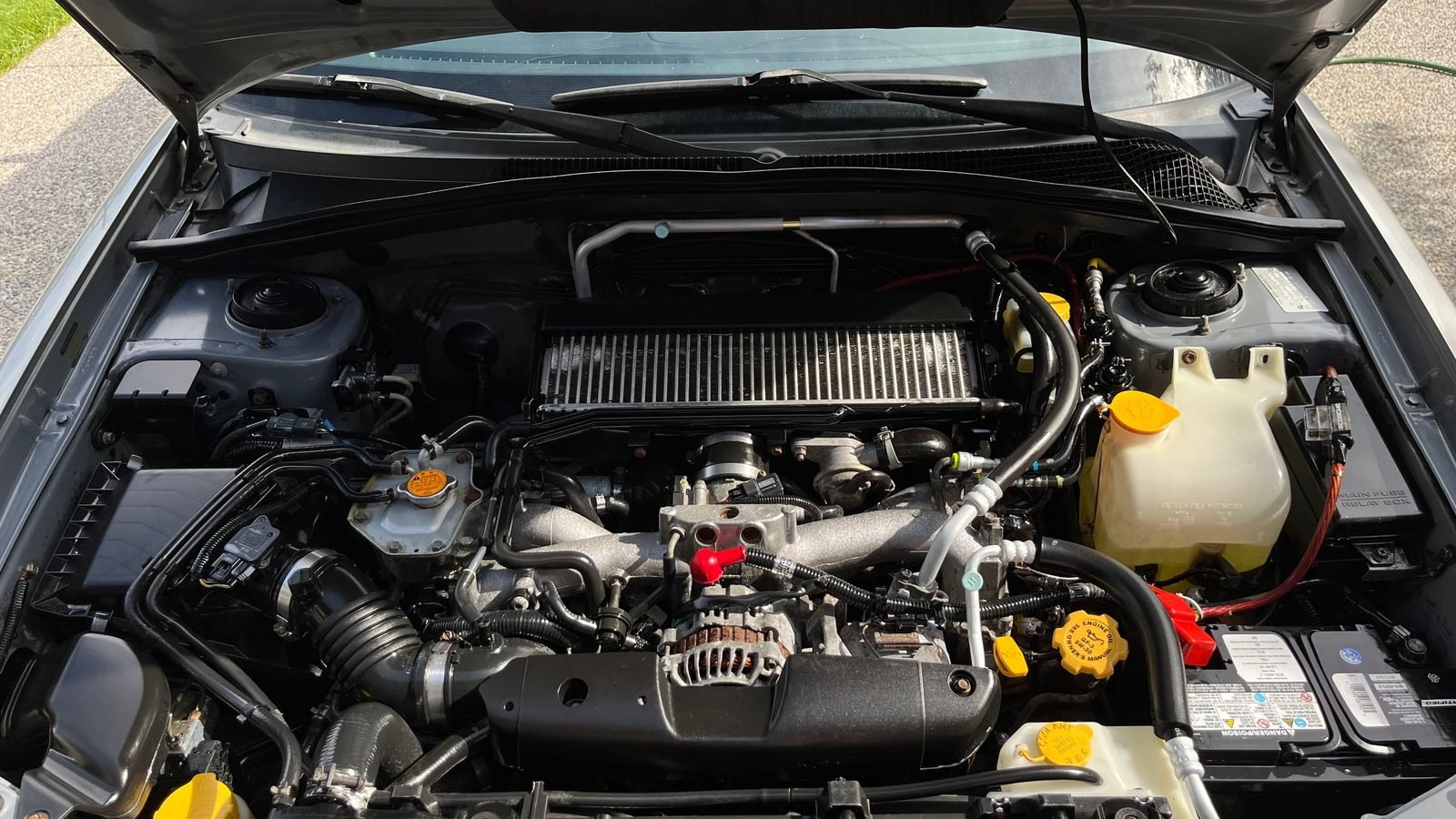 Cofre do motor aberto de um carro, com o sistema de admissão de ar à vista