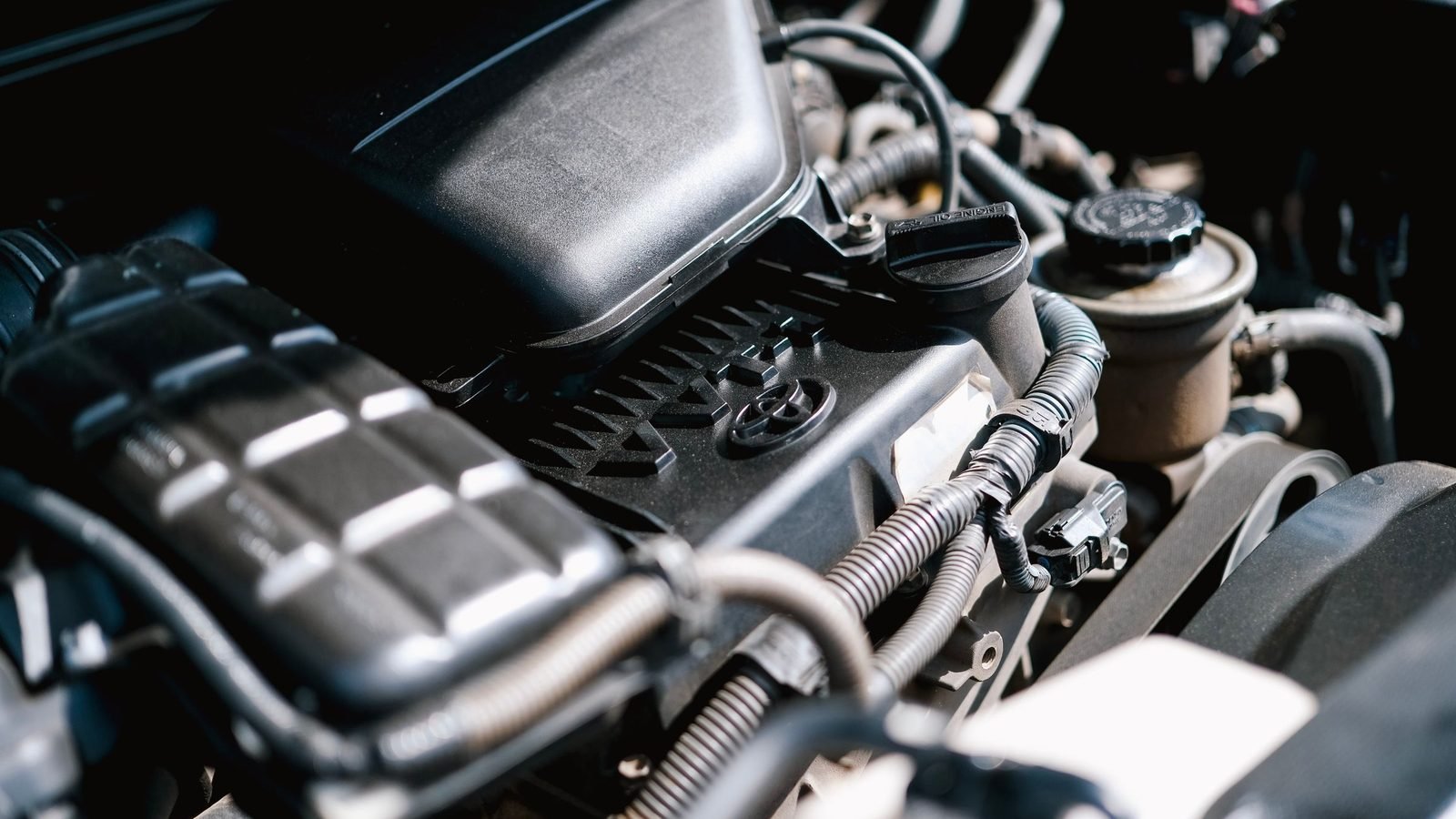 Motor de carro com o coletor de admissão de ar e as mangueiras à mostra