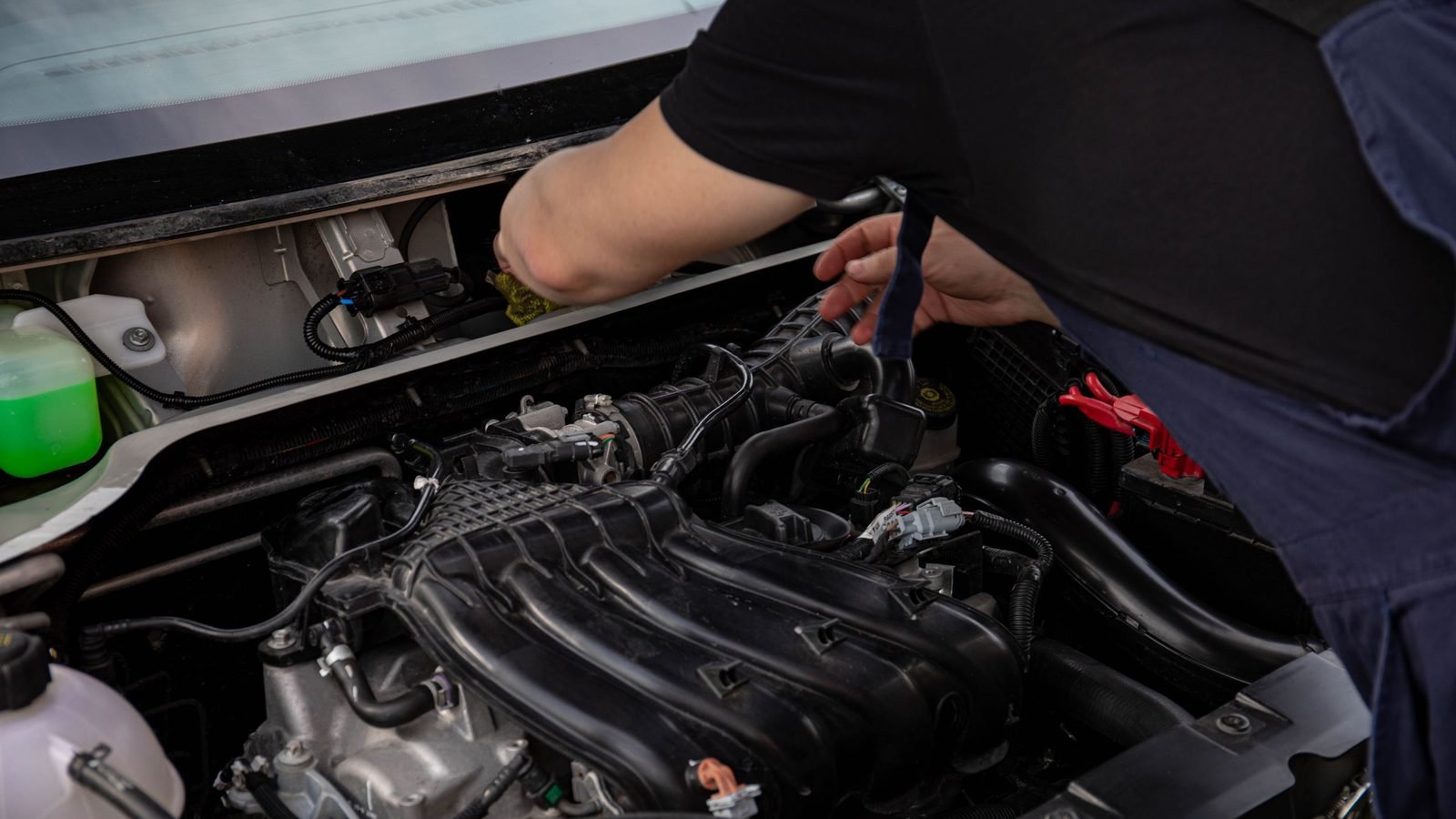 Mecânico inspecionando o motor de um carro com o capô aberto