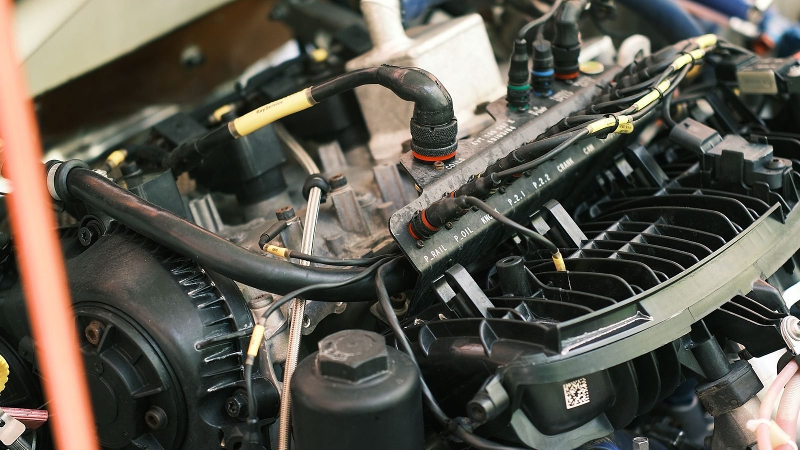 Motor de carro com mangueiras, chicotes e sensores à mostra